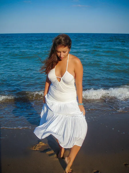 Arap genç bir kız, dolgun kalçalı, deniz kenarında dinleniyor, vücudunu gösteriyor, artı beden ölçülerinde bir kız.