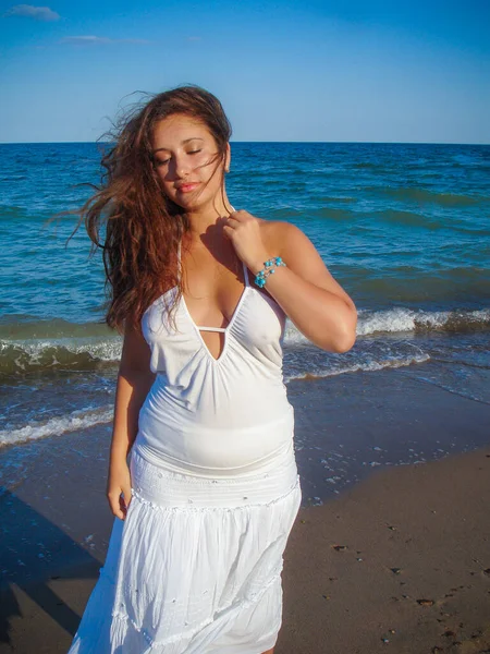 Arap genç bir kız, dolgun kalçalı, deniz kenarında dinleniyor, vücudunu gösteriyor, artı beden ölçülerinde bir kız.