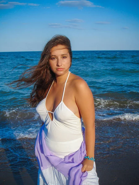 Arap genç bir kız, dolgun kalçalı, deniz kenarında dinleniyor, vücudunu gösteriyor, artı beden ölçülerinde bir kız.