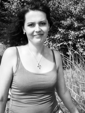 Olgun doğal bir kadın kırsalda dinlenir ve bir şeyler düşünür.