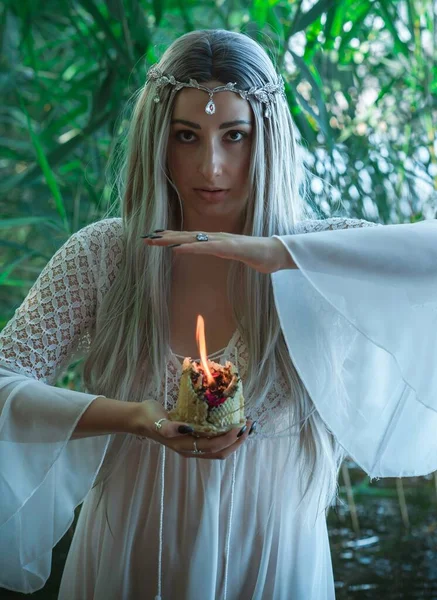 Old European magic, Mystical Pagan scene, woman in lake, rituals. Magic divination by candle of wax on the water, ritual. Psychic vision, fortune teller