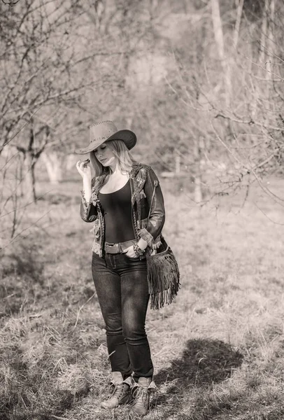 Girl in American country style leather boho jacket and cowboy hat at nature