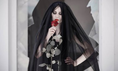 Siyah elbiseli gotik gelin, gül peçeli. Karanlık gelin, Cadılar Bayramı için kadınlar için parti fikirleri