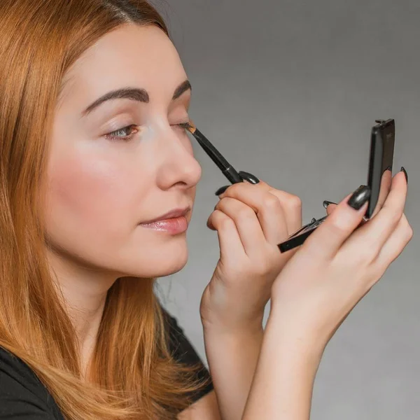 Evde makyaj yapan basit bir kız. Telafi süreci, adım adım. Göz makyajı.