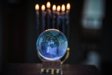 Sihirli kristal küre falcısı, aşk anlatıcısı, gizemli konsept, mumlu mistik sahne, masada tarot kartları.