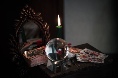 Avrupa, Ukrayna. Kiev July 7 : Illustrative Editorial. Sihirli kristal küre falcısı, aşk anlatıcısı, gizemli konsept, mumlu mistik sahne, masada tarot kartları.