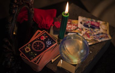 Avrupa, Ukrayna. Kiev July 7 : Illustrative Editorial. Sihirli kristal küre falcısı, aşk anlatıcısı, gizemli konsept, mumlu mistik sahne, masada tarot kartları.