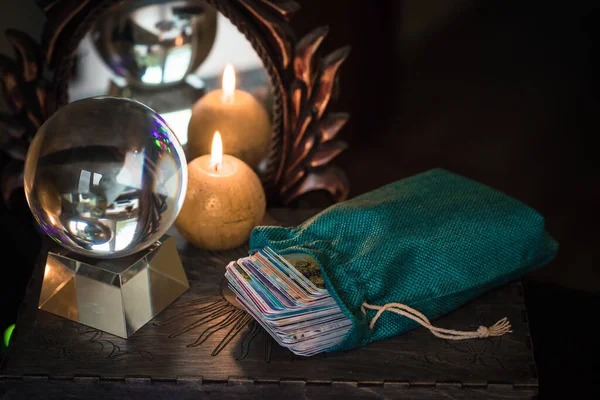 Magic crystal ball fortune teller ,love telling,  esoteric concept, mystical scene with candles, tarot cards on a table