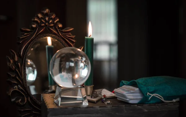 Magic crystal ball fortune teller ,love telling,  esoteric concept, mystical scene with candles, tarot cards on a table