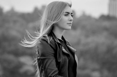 Uzun sarı saçlı, modaya uygun, modern bir kadın sokakta takılıyor. Süslü poz veren güzel bayan 