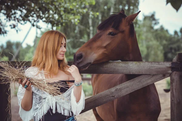 女人穿着时髦的波希米亚式休闲装 带着马在农场里 宠物动物在乡村牧场里 马是人类的朋友 — 图库照片