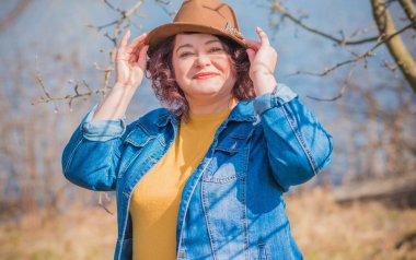 Olgun bir kadın, Amerikan ya da Avrupa 'da yürüyüş ve hayatın tadını çıkarmak. Kilolu bir kadın, şehir parkında şık giyinmiş. Doğal güzellik.