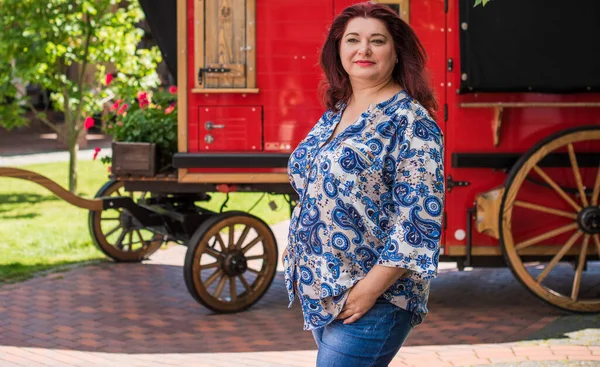 Mature plus size woman, American or European appearance walks and the  enjoying life. Lady with excess weight, stylishly dressed at the city park .Natural beauty