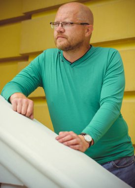 Olgun, sıradan bir hipster adamın portresi, kızıl sakallı bir adam Avrupa şehrinde yürüyor ve bir şeyler düşünüyor.