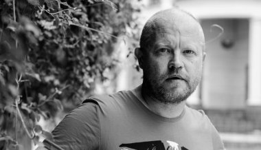 Olgun, sıradan bir hipster adamın portresi, kızıl sakallı bir adam Avrupa şehrinde yürüyor ve bir şeyler düşünüyor.