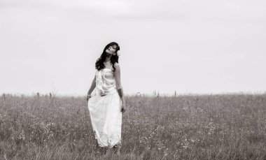 Klasik tonlarda romantik bir portre ve dantelli elbiseli bir kadın sahada duruyor ve doğa ile eğleniyor. Kendini sevme ve çevreyle uyum kavramı.