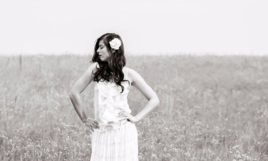 Klasik tonlarda romantik bir portre ve dantelli elbiseli bir kadın sahada duruyor ve doğa ile eğleniyor. Kendini sevme ve çevreyle uyum kavramı.