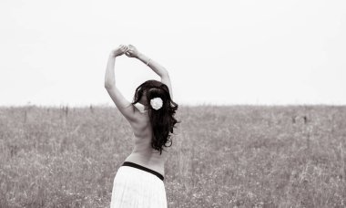 Klasik tonlarda romantik bir portre ve dantelli elbiseli bir kadın sahada duruyor ve doğa ile eğleniyor. Kendini sevme ve çevreyle uyum kavramı.