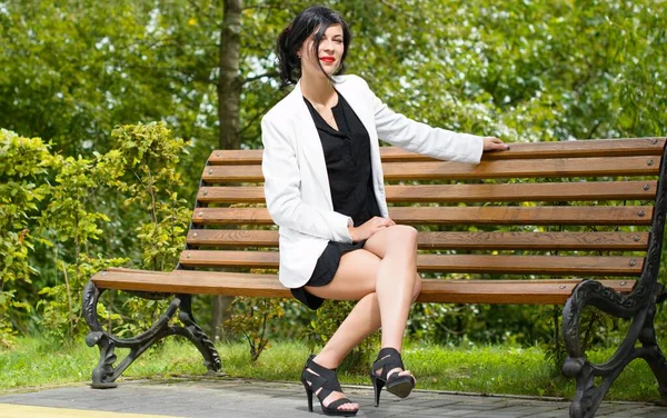 Business woman after work near her office. Stylish dressed woman in black dress and white jacket at the city