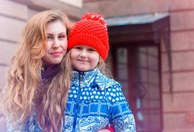 Genç bir anne ve kızı iyi bir ruh haliyle şehirde yürüyorlar. Şehirde çocuklu bir anne yürüyüşün tadını çıkarıyor.