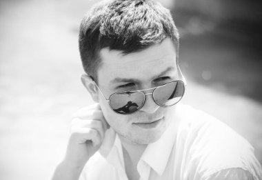  Şehirde güneş gözlüklü genç bir adam portresi. Öğrenci Avrupa 'nın merkezinde yürüyor 