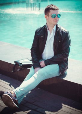  Şehirde güneş gözlüklü genç bir adam portresi. Öğrenci Avrupa 'nın merkezinde yürüyor 