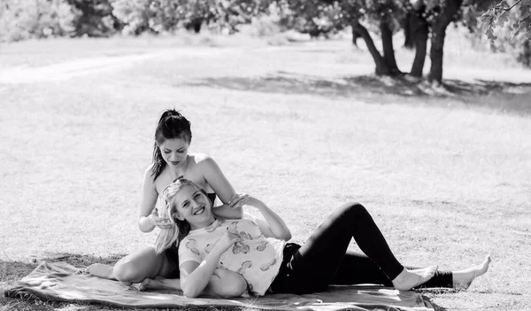 两名年轻女子在公园里休息 做体操 并在户外玩乐 在阳光灿烂的早晨 漂亮的姑娘们心情很好 朋友们在树旁嬉笑 — 图库照片