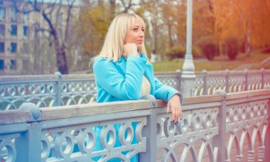 Şehirde yürüyen mavi ceketli çekici orta yaşlı kadın. Artı Avrupa 'nın sokak modasında poz veren modacı kadın portresi