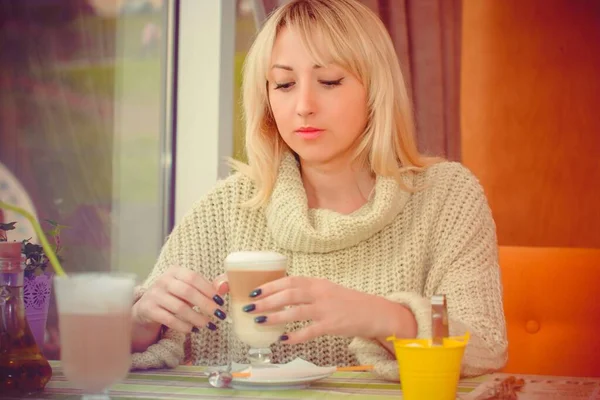 Woman sitting in a cozy cafe white coffee break, Woman enjoying coffee after hours, woman having breakfast in a cozy cafe in the early morning, Autumn mood, Christmas mood