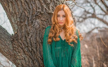 Boho modern tarzı, dantelli yeşil bluz ve etek giyen kızıl saçlı kız. Genç, romantik, kızıl saçlı, sıradan bir kadın, yaşam tarzı portresi.