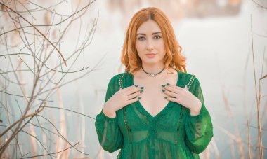 Boho modern tarzı, dantelli yeşil bluz ve etek giyen kızıl saçlı kız. Genç, romantik, kızıl saçlı, sıradan bir kadın, yaşam tarzı portresi.