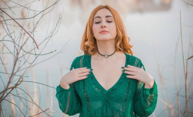 Boho modern tarzı, dantelli yeşil bluz ve etek giyen kızıl saçlı kız. Genç, romantik, kızıl saçlı, sıradan bir kadın, yaşam tarzı portresi.