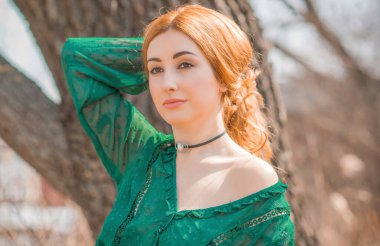 Boho modern tarzı, dantelli yeşil bluz ve etek giyen kızıl saçlı kız. Genç, romantik, kızıl saçlı, sıradan bir kadın, yaşam tarzı portresi.