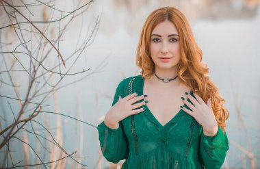 Boho modern tarzı, dantelli yeşil bluz ve etek giyen kızıl saçlı kız. Genç, romantik, kızıl saçlı, sıradan bir kadın, yaşam tarzı portresi.