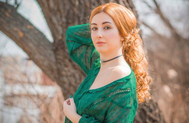 Boho modern tarzı, dantelli yeşil bluz ve etek giyen kızıl saçlı kız. Genç, romantik, kızıl saçlı, sıradan bir kadın, yaşam tarzı portresi.