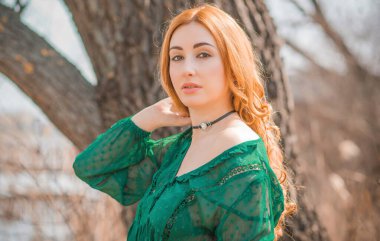 Boho modern tarzı, dantelli yeşil bluz ve etek giyen kızıl saçlı kız. Genç, romantik, kızıl saçlı, sıradan bir kadın, yaşam tarzı portresi.