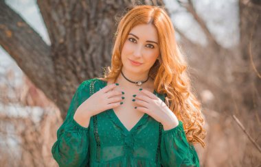 Boho modern tarzı, dantelli yeşil bluz ve etek giyen kızıl saçlı kız. Genç, romantik, kızıl saçlı, sıradan bir kadın, yaşam tarzı portresi.