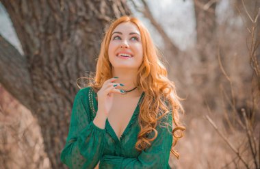 Boho modern tarzı, dantelli yeşil bluz ve etek giyen kızıl saçlı kız. Genç, romantik, kızıl saçlı, sıradan bir kadın, yaşam tarzı portresi.