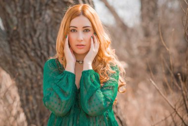 Boho modern tarzı, dantelli yeşil bluz ve etek giyen kızıl saçlı kız. Genç, romantik, kızıl saçlı, sıradan bir kadın, yaşam tarzı portresi.