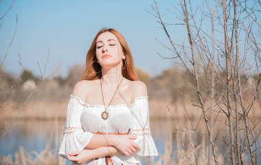 Doğa görünüşü, ortaçağ tarzı kıyafetler, pamuklu, klasik bluz, kemer ve etek giyen kızıl saçlı kadın.