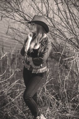 Kovboy kız sonbahar stili, L figürü kadın deri ceket, kot pantolon ve şapka.