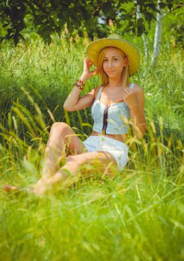 Doğal yüz rötuş yok, trend. Sarışın, romantik, sıradan ve hoş bir kız hafta sonu istirahatinde ve doğada iyi vakit geçiriyor.