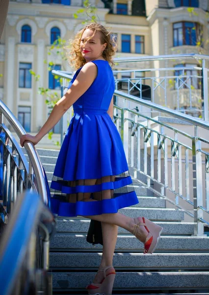 ブロンド髪巻き女性プラスサイズヨーロッパの外観で青レトロドレス街を歩くで日当たりの良い暖かい日で良い気分 — ストック写真