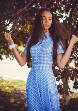 Güzel, genç, sıska bir kız uzun bir elbiseyle şehirde dolaşıyor ve günün tadını çıkarıyor.