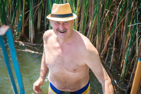 Happy senior man swiming at water, at nature and rest, lifestyle of people on retired