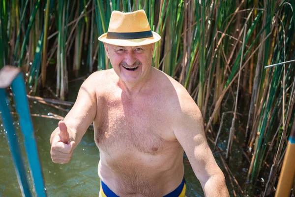 Happy senior man swiming at water, at nature and rest, lifestyle of people on retired