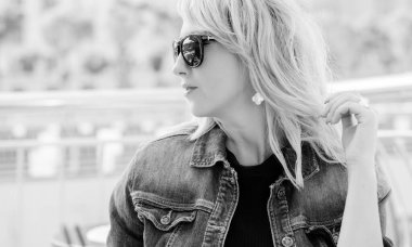 Güzel, şık bir kadın erkek arkadaşını bir randevuda bekliyor. Şehir merkezinde, mimarinin arka planındaki kafede güzel bir bayan.