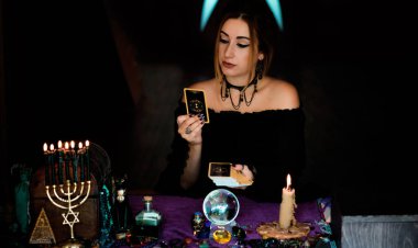  Tarot kartlarındaki kadın falcı, kehanet kavramı, sihirli ritüeller ve masanın üzerindeki cadı unsurları.