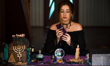  Tarot kartlarındaki kadın falcı, kehanet kavramı, sihirli ritüeller ve masanın üzerindeki cadı unsurları.