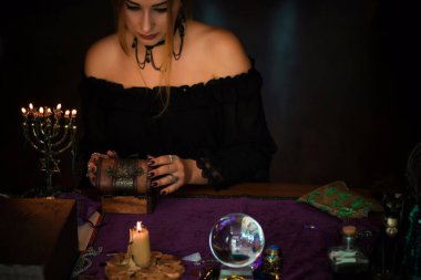  Tarot kartlarındaki kadın falcı, kehanet kavramı, sihirli ritüeller ve masanın üzerindeki cadı unsurları.